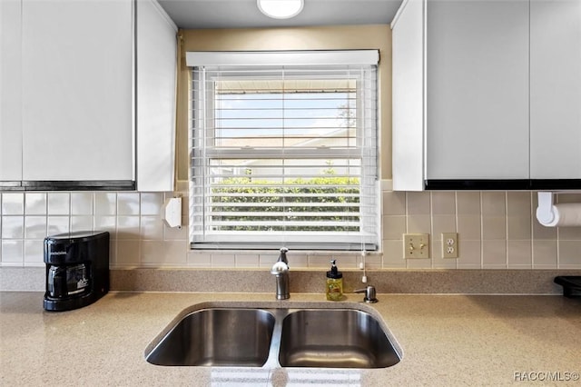 kitchen with sink, white cabinets, and decorative backsplash