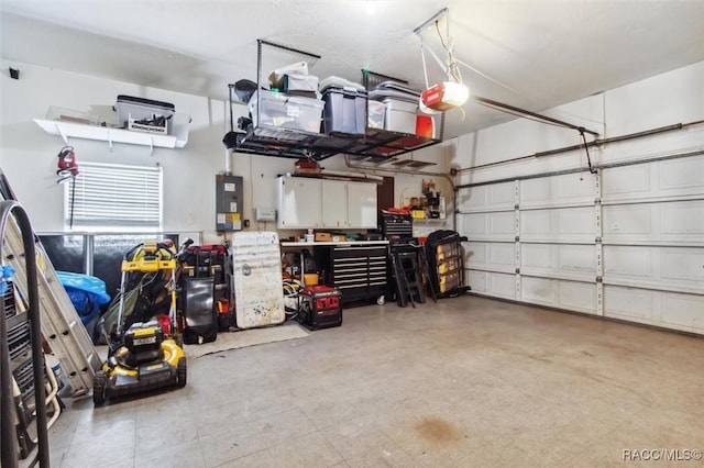 garage with a garage door opener, electric panel, and a workshop area