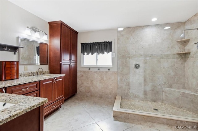 bathroom with vanity, tile walls, and tiled shower