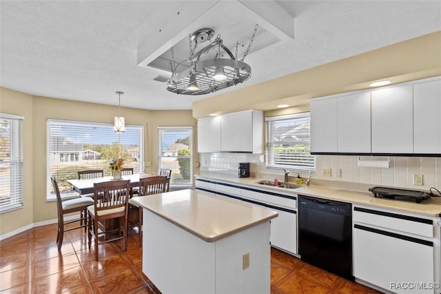 kitchen with sink, decorative light fixtures, black dishwasher, a kitchen island, and white cabinets