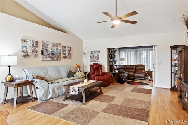 living room featuring ceiling fan, lofted ceiling, and light wood-type flooring