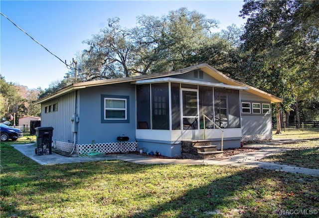 view of front facade with a sunroom and a front lawn