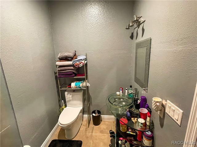 bathroom with tile patterned flooring, toilet, and sink