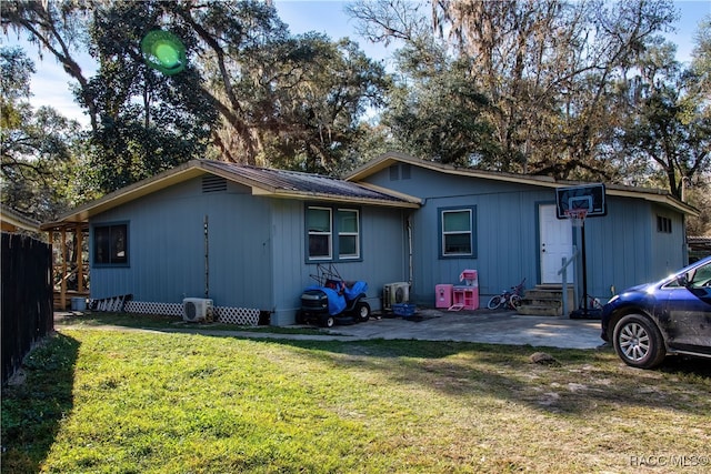 back of house featuring a lawn and a patio