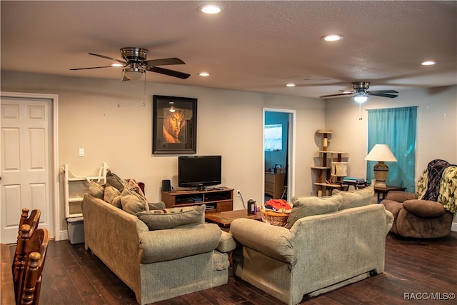 living room featuring ceiling fan and dark wood-type flooring