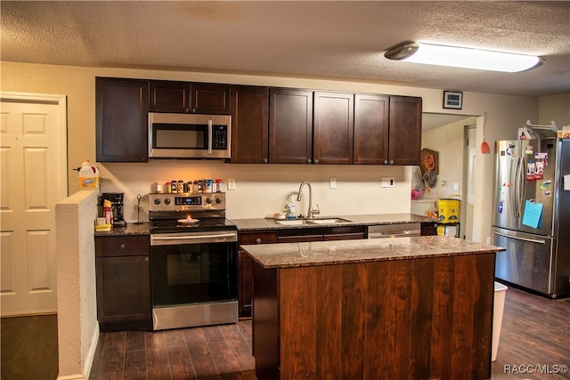 kitchen with a center island, dark wood-type flooring, sink, dark brown cabinets, and stainless steel appliances