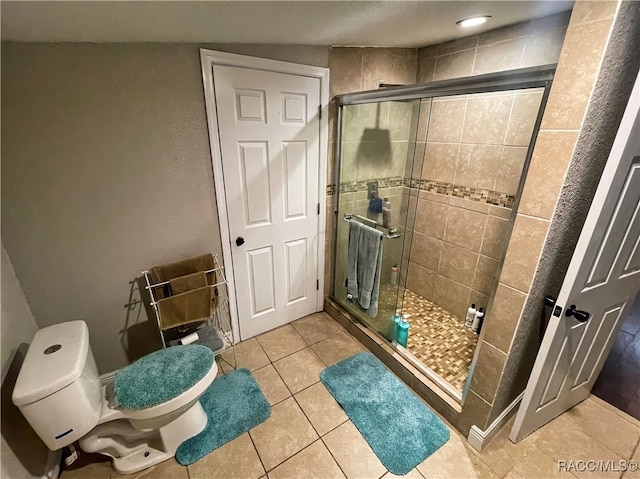 bathroom featuring tile patterned flooring, an enclosed shower, and toilet