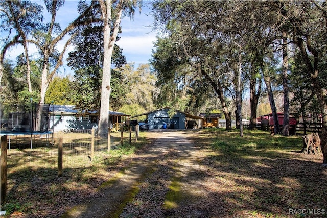 view of yard with an outdoor structure and a trampoline