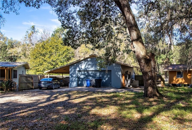 view of side of home with a garage, an outdoor structure, and a carport