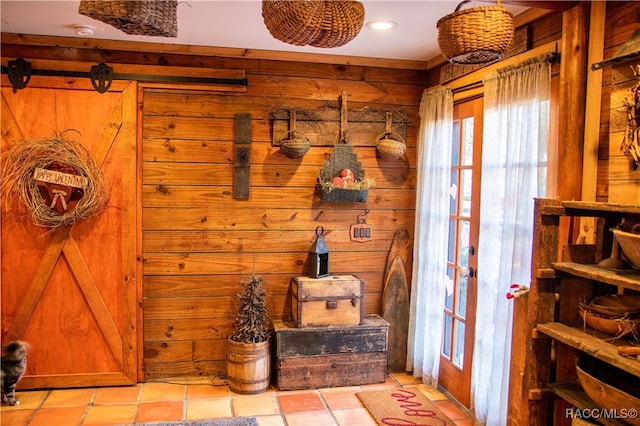 mudroom with wood walls and light tile patterned flooring