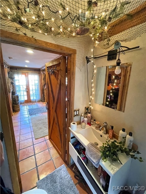 interior space with light tile patterned flooring, french doors, and sink