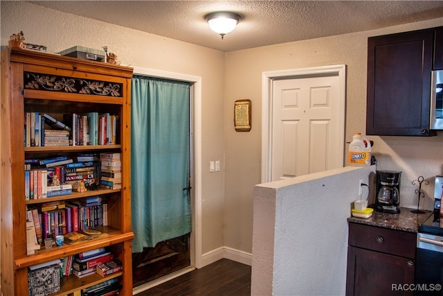 interior space featuring a textured ceiling and dark hardwood / wood-style floors