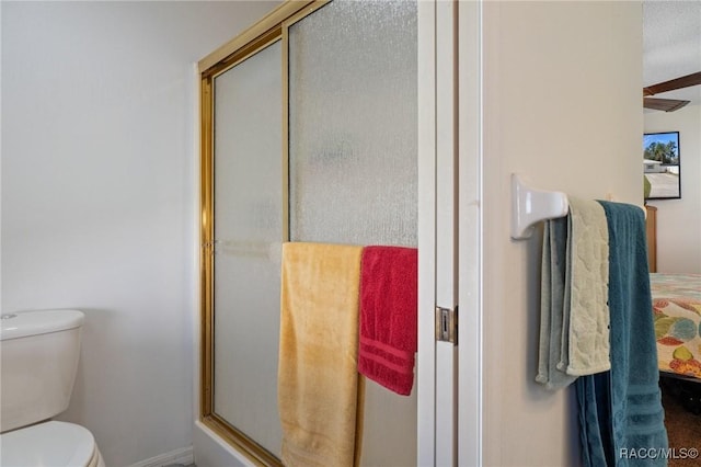 full bath featuring a stall shower and toilet