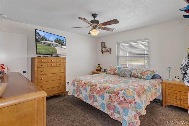 bedroom featuring dark colored carpet, ceiling fan, and a textured ceiling