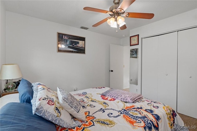 carpeted bedroom featuring ceiling fan, a closet, and visible vents