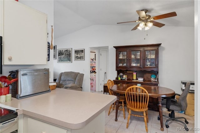 kitchen featuring lofted ceiling, ceiling fan, a peninsula, light countertops, and glass insert cabinets