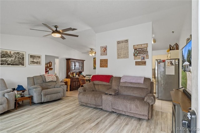 living area featuring lofted ceiling, ceiling fan, and light wood finished floors