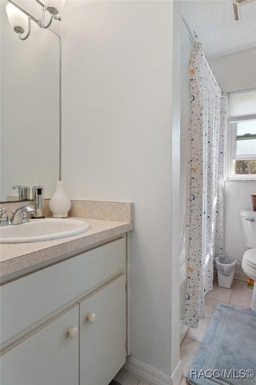 bathroom with toilet, tile patterned floors, visible vents, vanity, and shower / tub combo with curtain