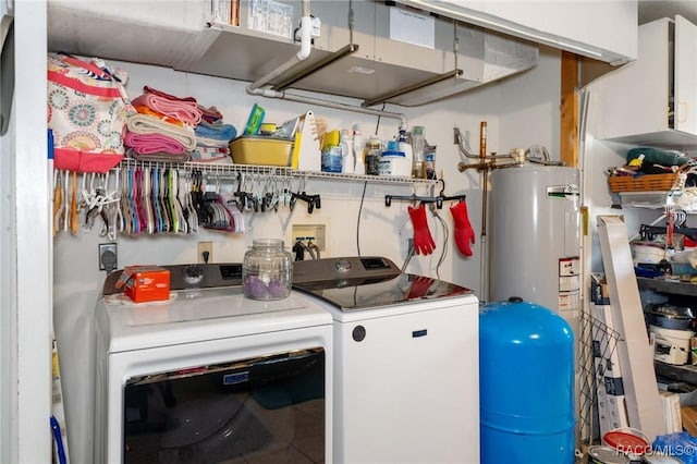 utility room featuring water heater and independent washer and dryer