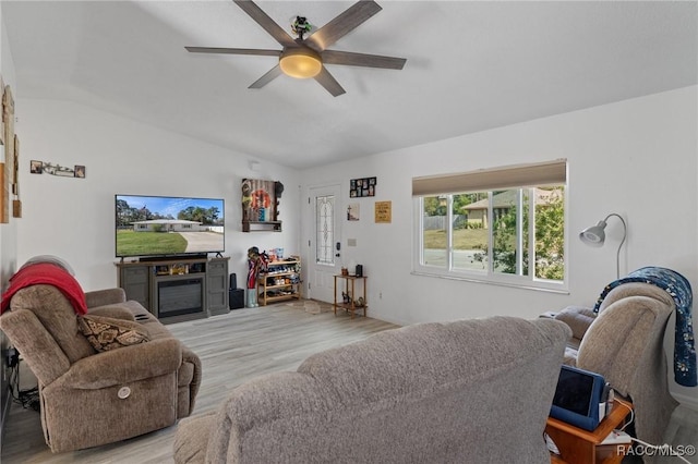 living room featuring light wood finished floors, ceiling fan, and vaulted ceiling