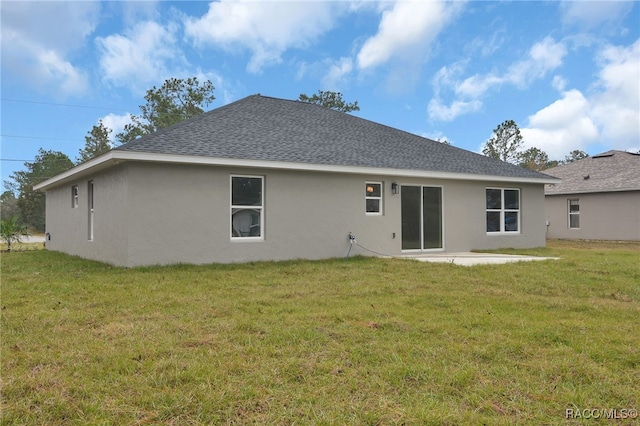 rear view of property featuring a lawn