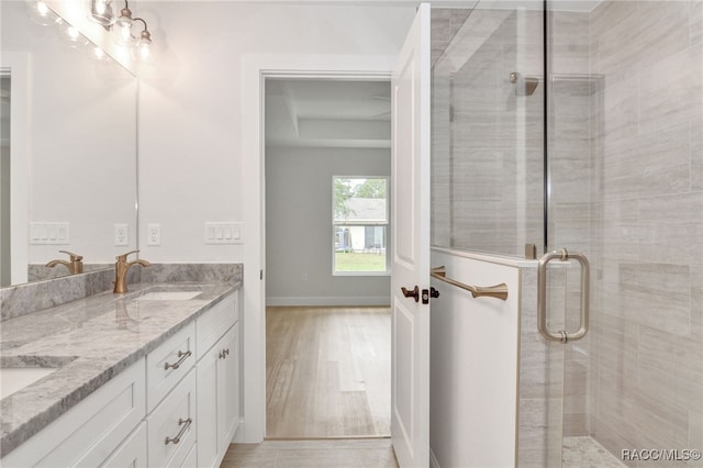 bathroom with hardwood / wood-style floors, vanity, and walk in shower