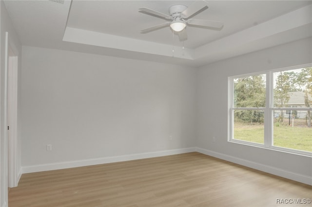 6526 N Earlshire Ter, Citrus Springs, FL 34434 - unfurnished room featuring light wood finished floors, a raised ceiling, and a ceiling fan