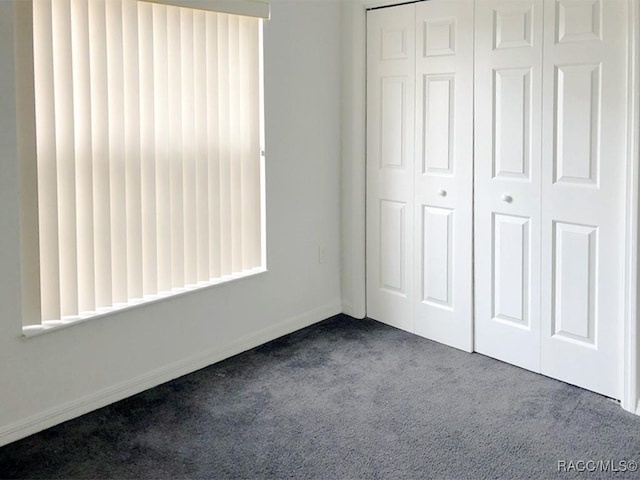 unfurnished bedroom featuring carpet and a closet