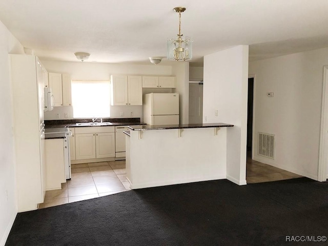 kitchen with light tile patterned flooring, sink, white cabinetry, decorative light fixtures, and white appliances