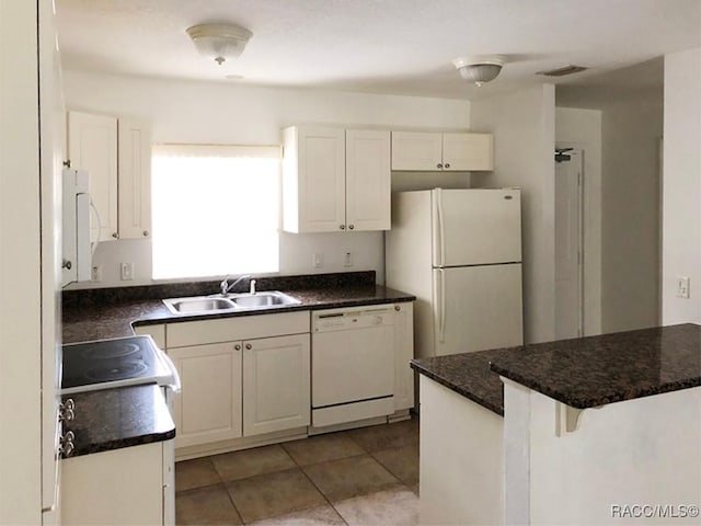 kitchen featuring sink, a breakfast bar area, light tile patterned floors, white appliances, and white cabinets