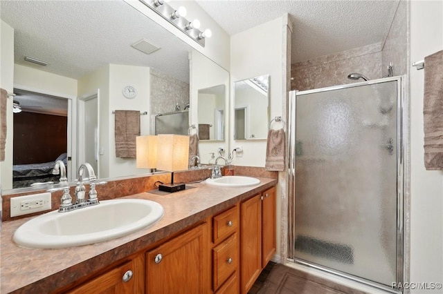 bathroom with vanity, a textured ceiling, and walk in shower