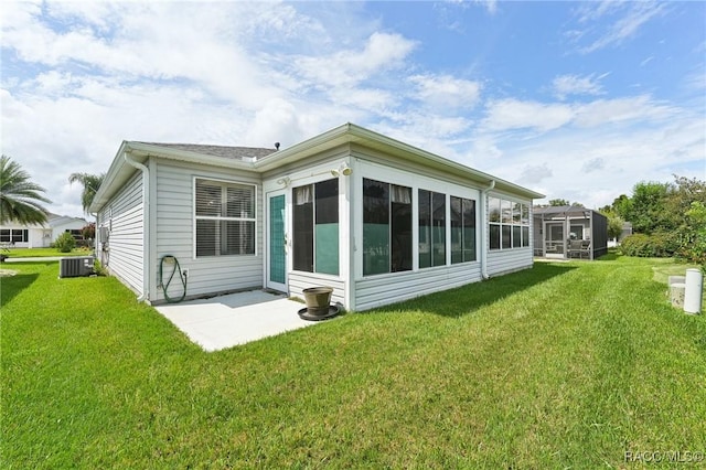 back of house featuring a sunroom, a yard, a patio, and central AC unit