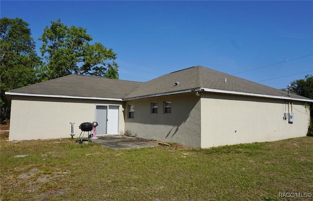 back of property featuring stucco siding, a yard, and a patio
