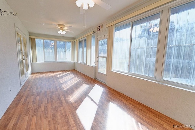 unfurnished sunroom with ceiling fan