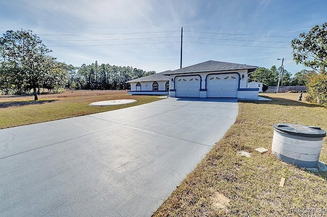 single story home featuring a garage and a front lawn