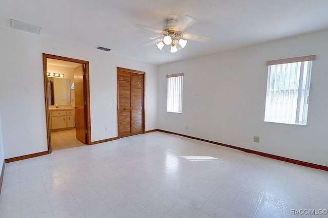 unfurnished bedroom featuring sink, a closet, ceiling fan, and ensuite bathroom