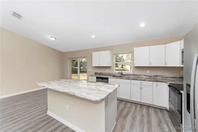 kitchen with white cabinets, appliances with stainless steel finishes, and a center island