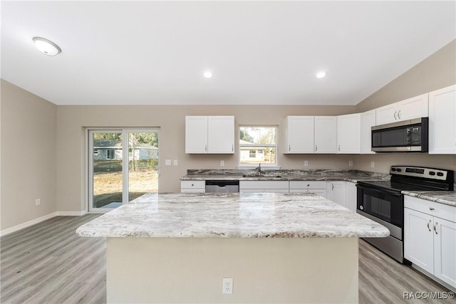 kitchen featuring a kitchen island, white cabinets, and stainless steel appliances