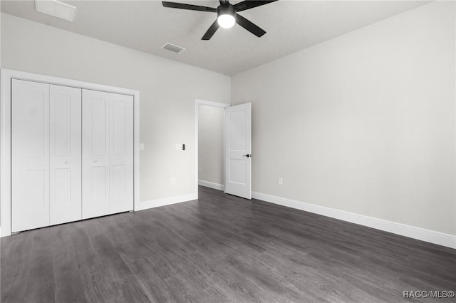 unfurnished bedroom featuring dark hardwood / wood-style flooring, a closet, and ceiling fan