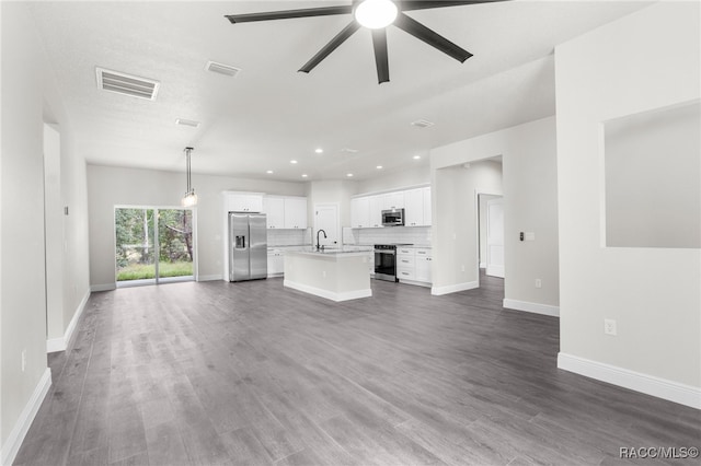 unfurnished living room with ceiling fan, sink, and dark hardwood / wood-style floors