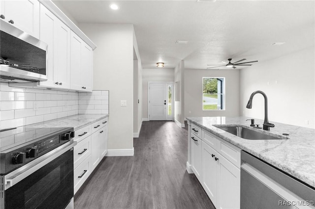 kitchen featuring sink, light stone counters, stainless steel appliances, decorative backsplash, and white cabinets