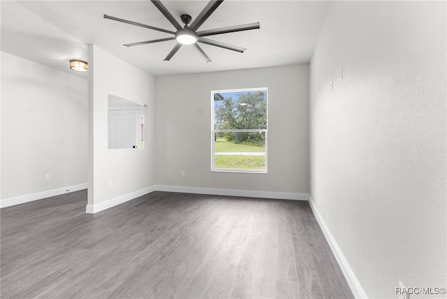 unfurnished room with dark wood-type flooring and ceiling fan