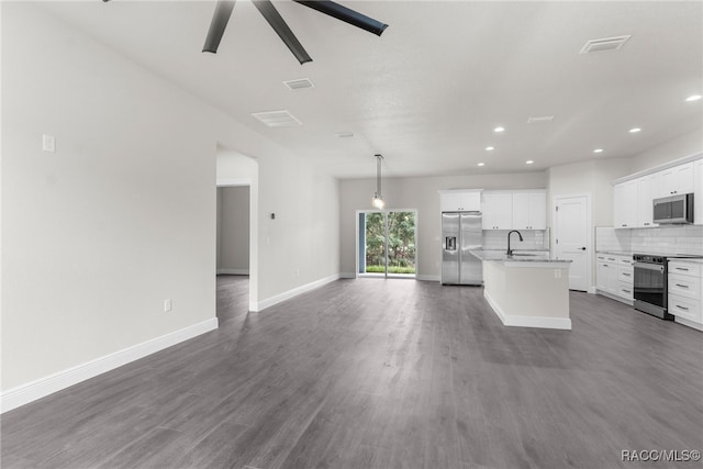 kitchen with appliances with stainless steel finishes, white cabinetry, an island with sink, sink, and decorative backsplash