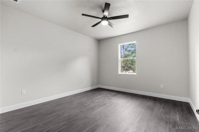 empty room with a textured ceiling, dark wood-type flooring, and ceiling fan