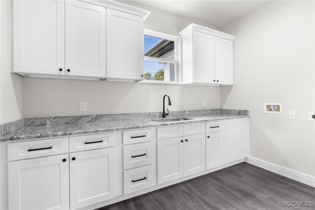 kitchen featuring white cabinetry, sink, light stone counters, and dark hardwood / wood-style floors