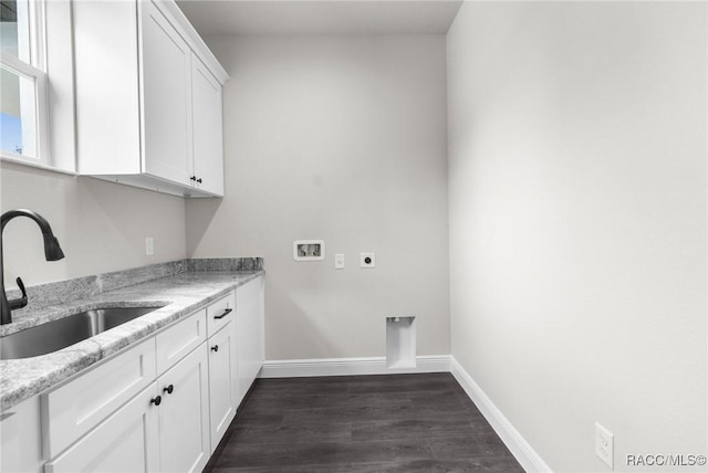 washroom featuring sink, dark hardwood / wood-style flooring, cabinets, hookup for a washing machine, and hookup for an electric dryer