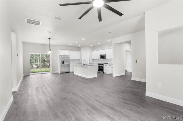 unfurnished living room with sink, dark wood-type flooring, and ceiling fan