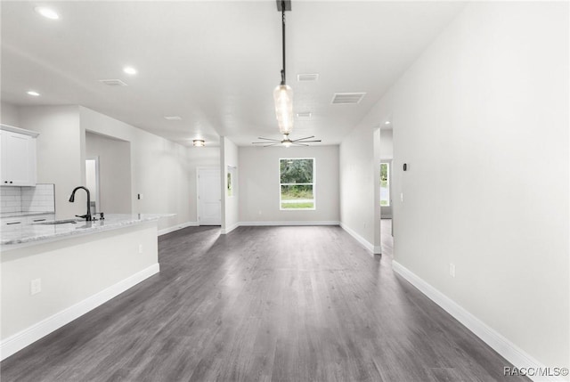 unfurnished living room with ceiling fan, dark hardwood / wood-style floors, and sink