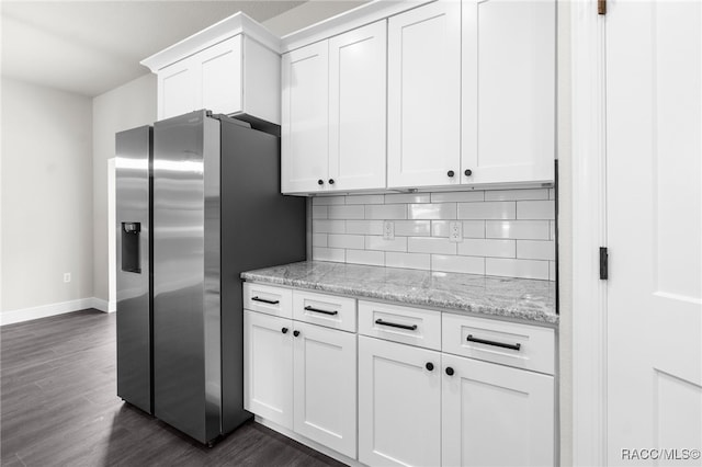 kitchen featuring white cabinetry, light stone counters, stainless steel fridge with ice dispenser, and decorative backsplash