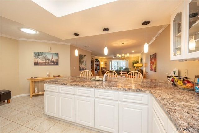 kitchen featuring hanging light fixtures, white cabinetry, and ornamental molding